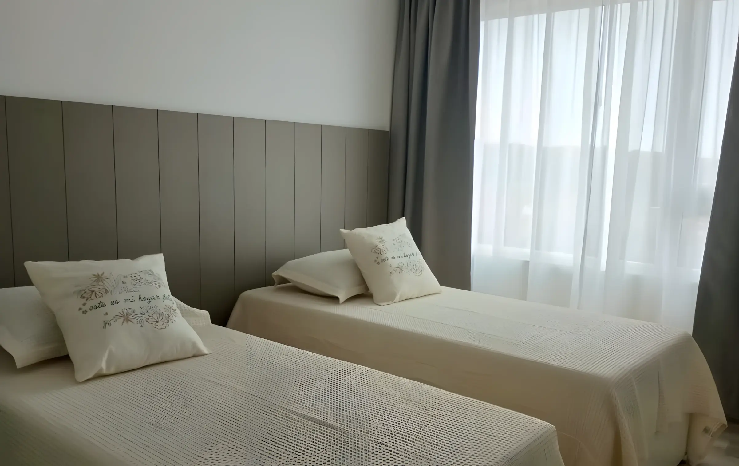 Dormitorio con dos camas individuales junto a la ventana