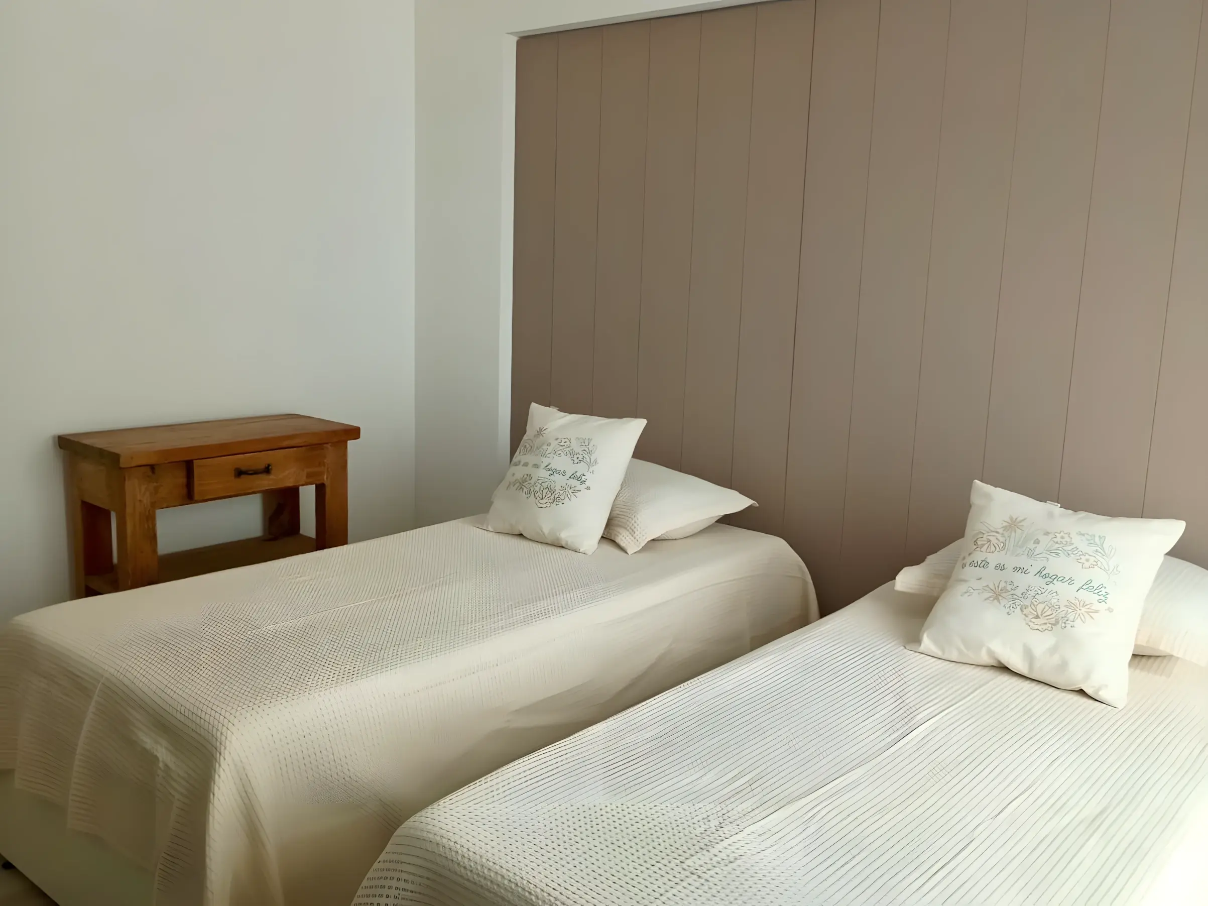 Dos camas individuales con mesa de luz de madera