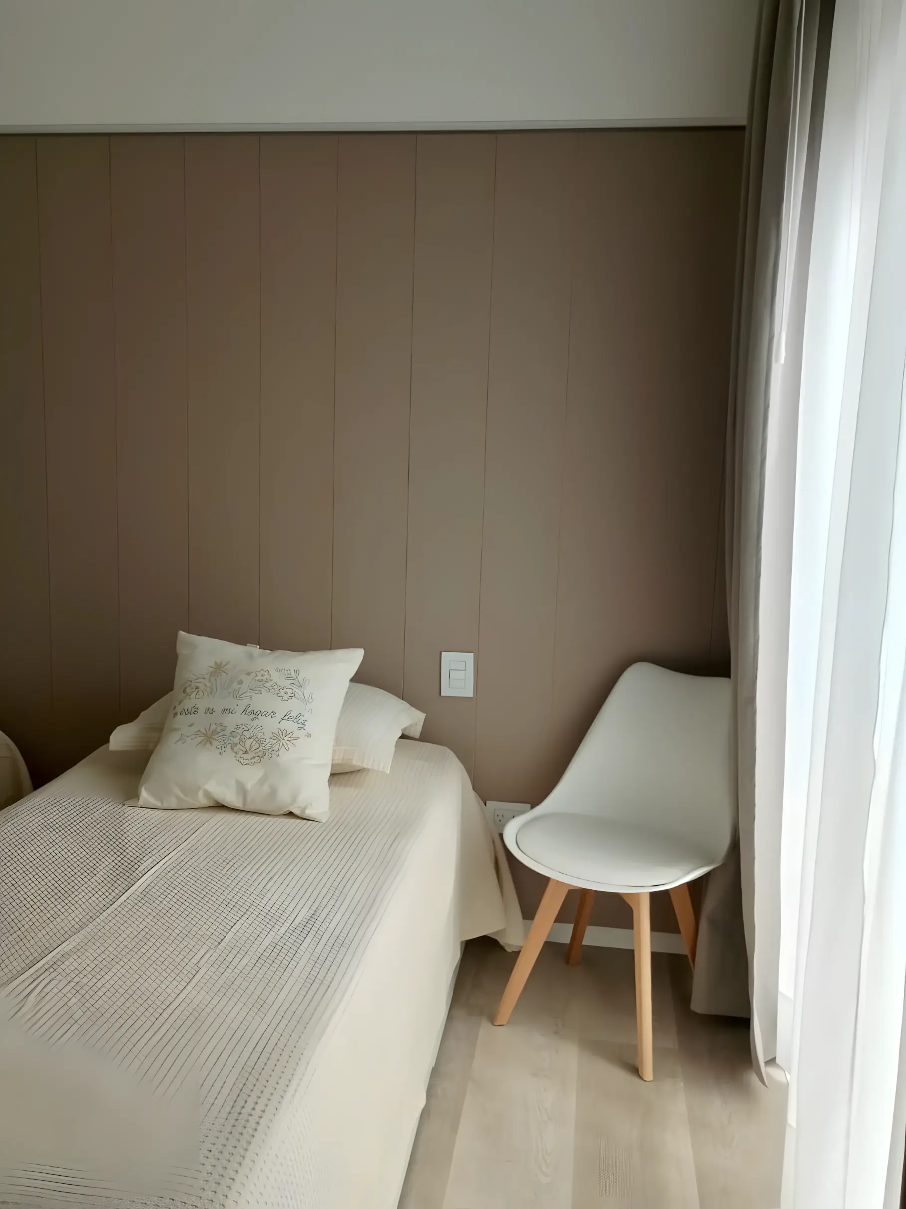 Cama individual con silla junto a la ventana