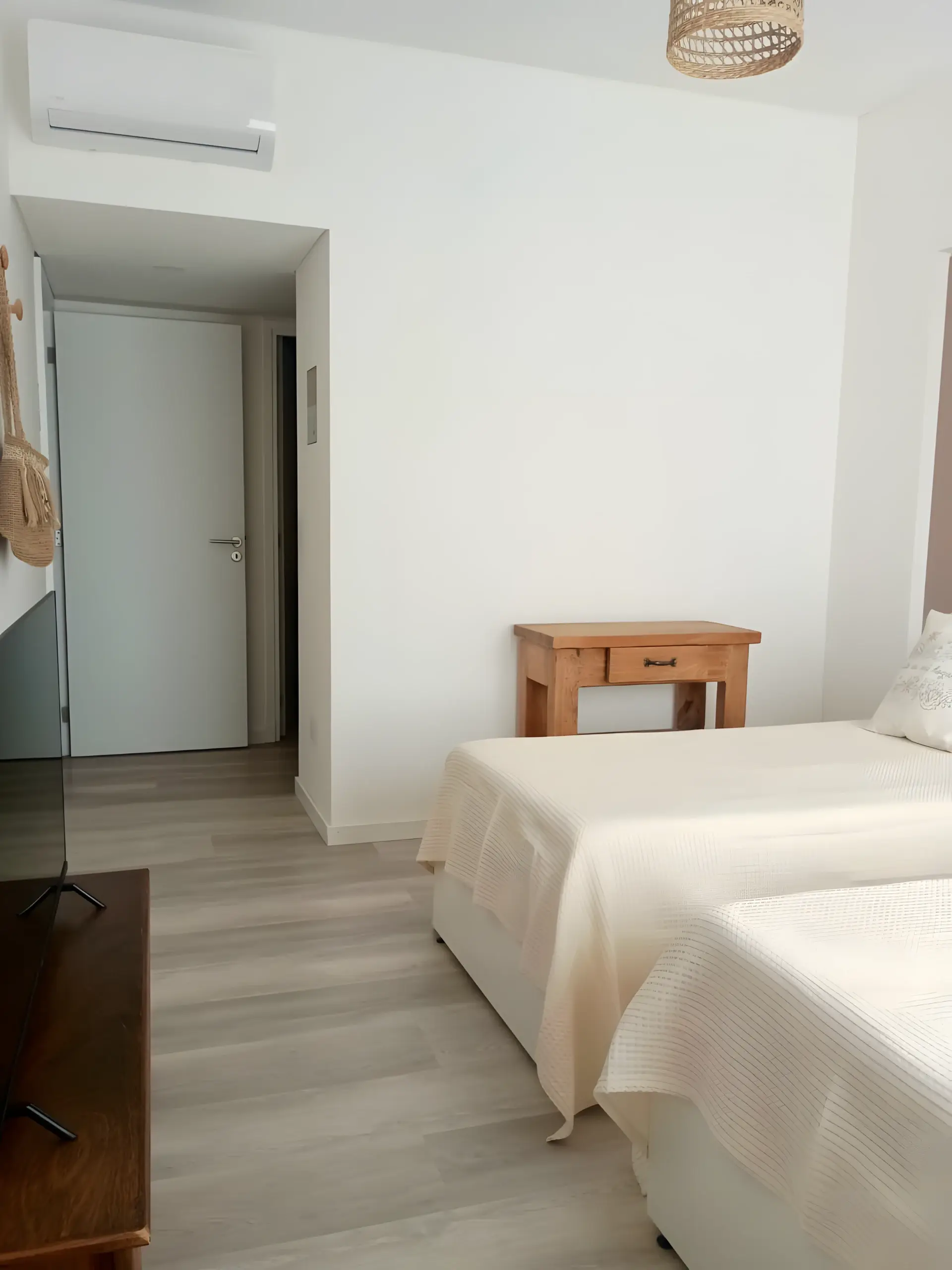 Dormitorio de dos camas con placard y televisor