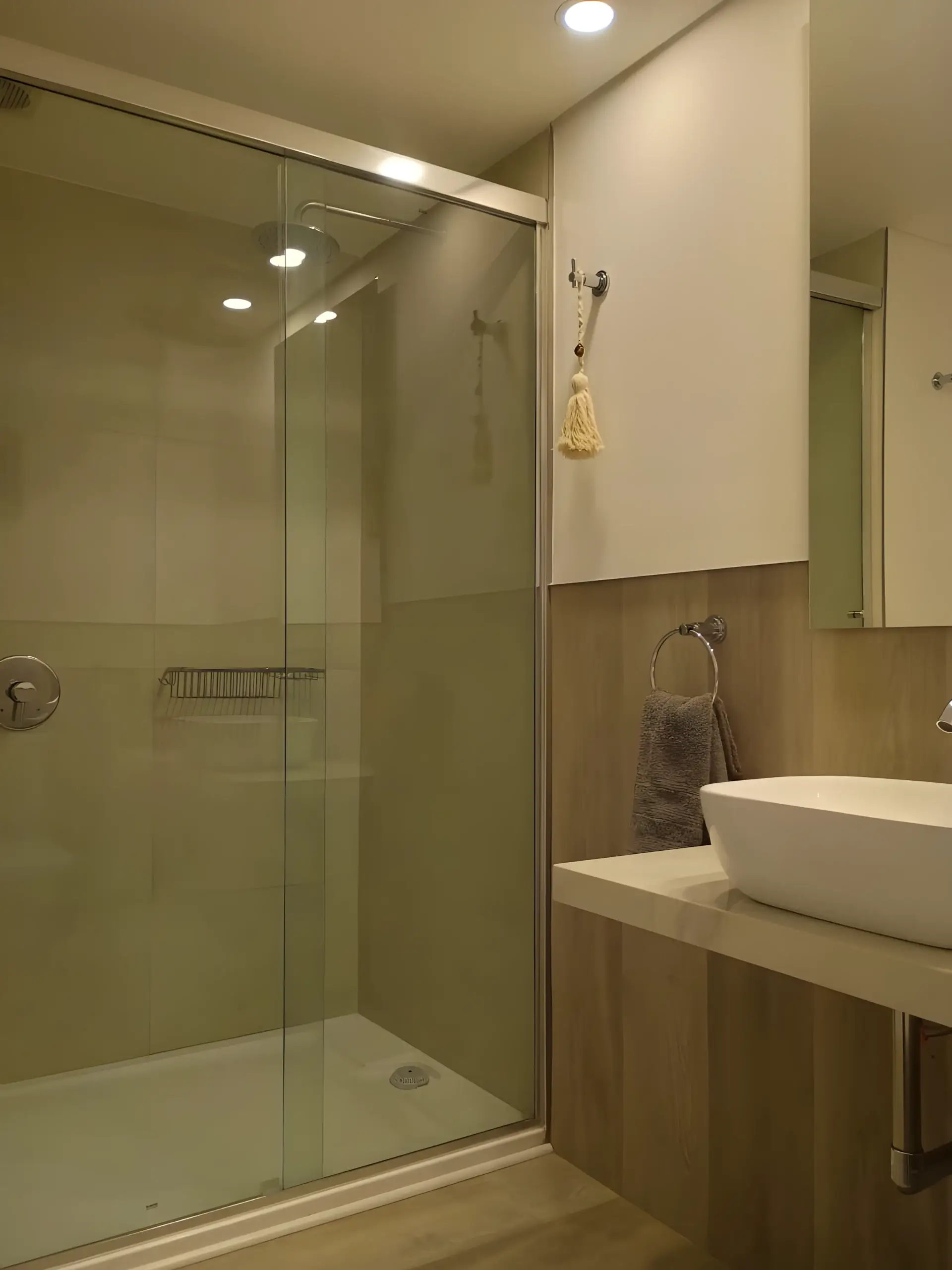 Ducha con mampara de vidrio y revestimiento de madera